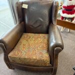 Distressed brown leather chair with nailheads