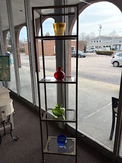 brass and glass shelving unit